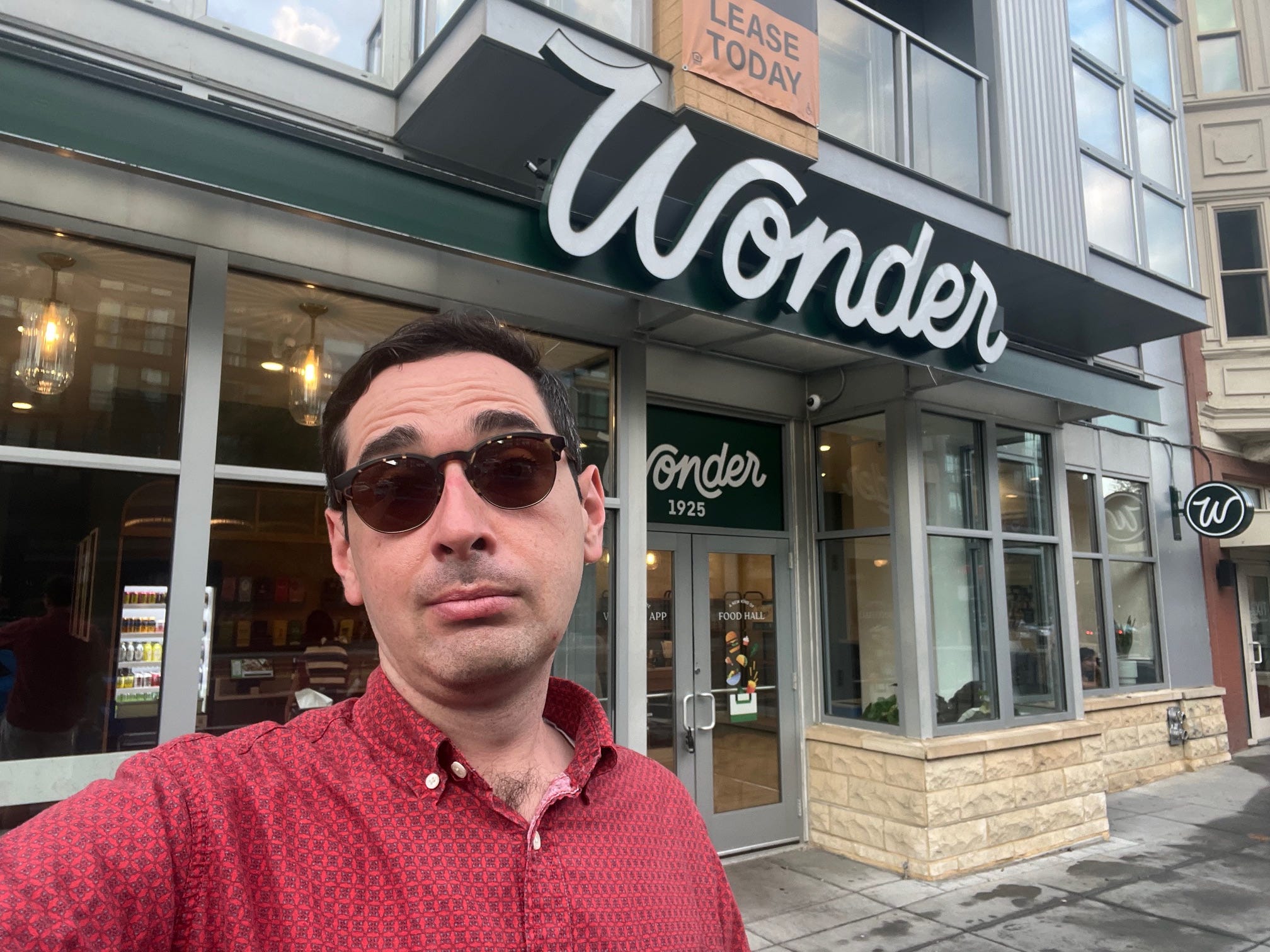 The reporter standing outside of Wonder's food hall on 14th Street in Washington, DC