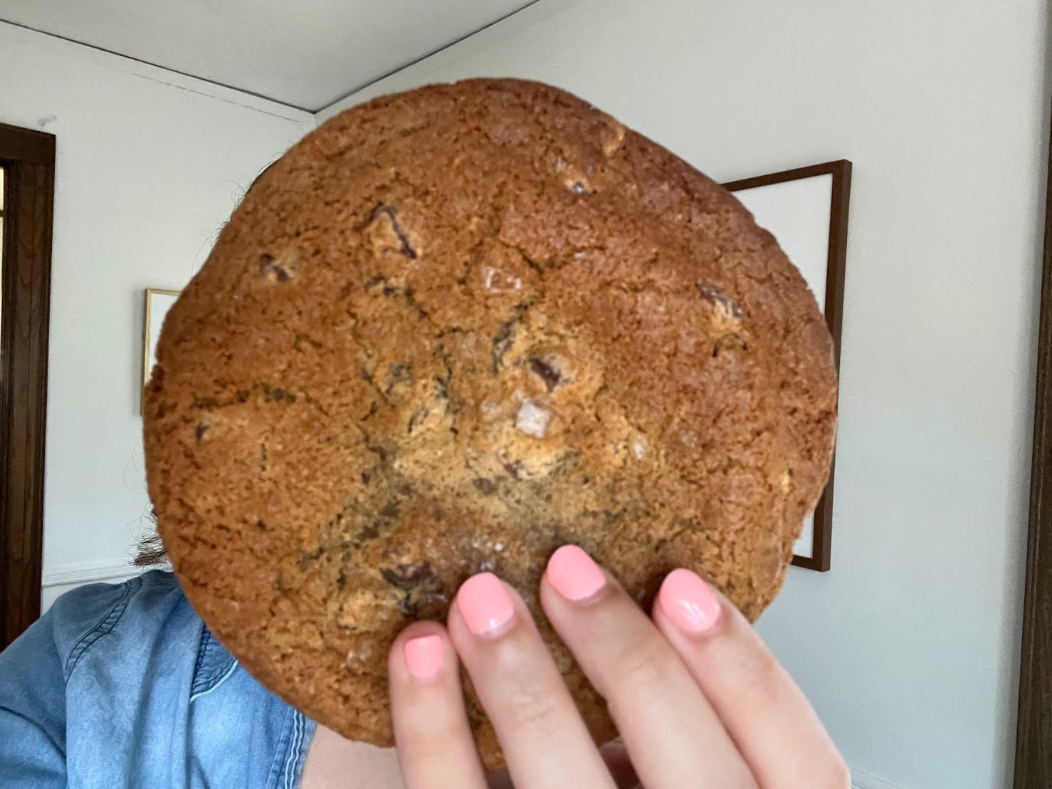 The author holds a cookie from Wonder in front of her face