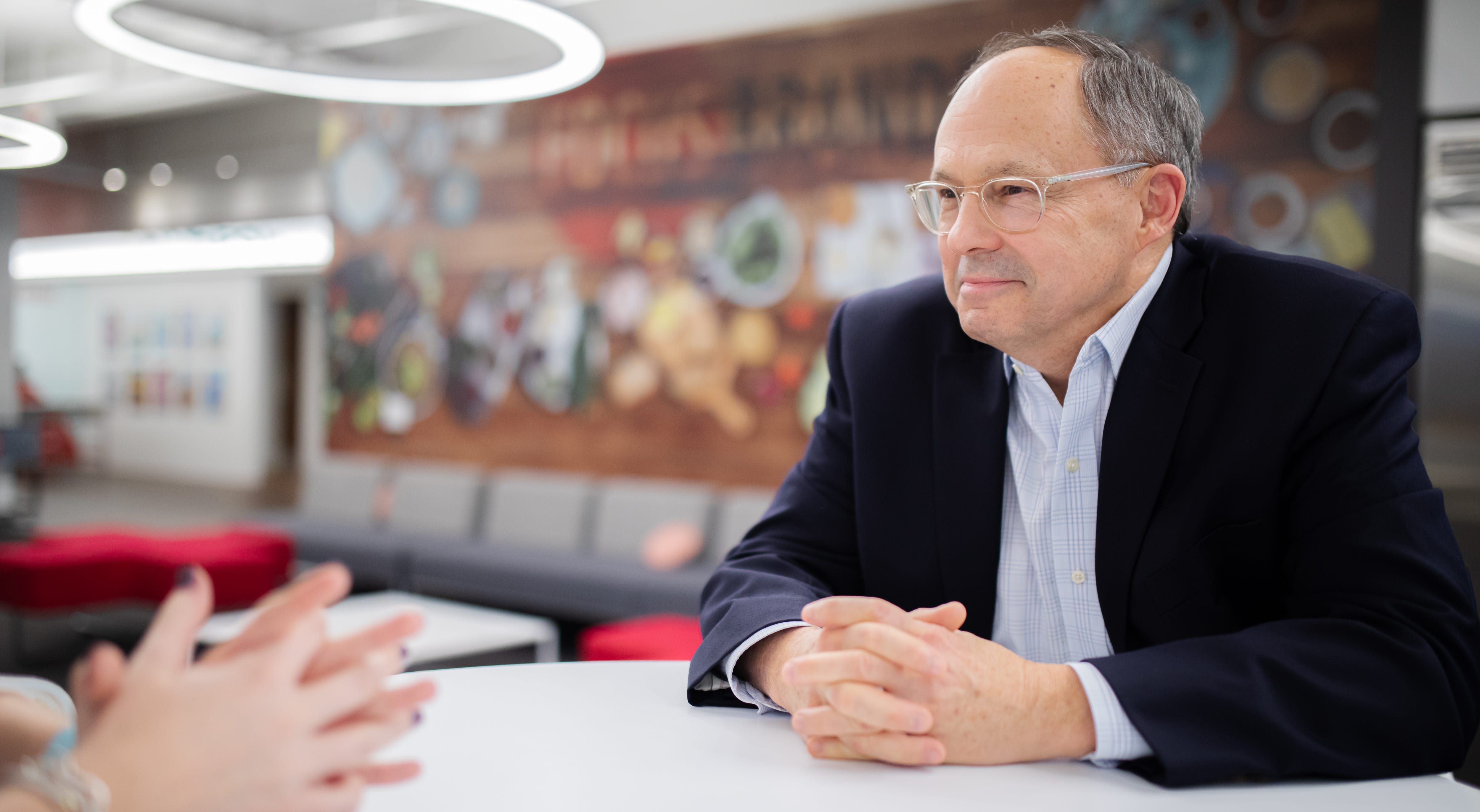 Jim Holthouser speaks to a colleague during a meeting.