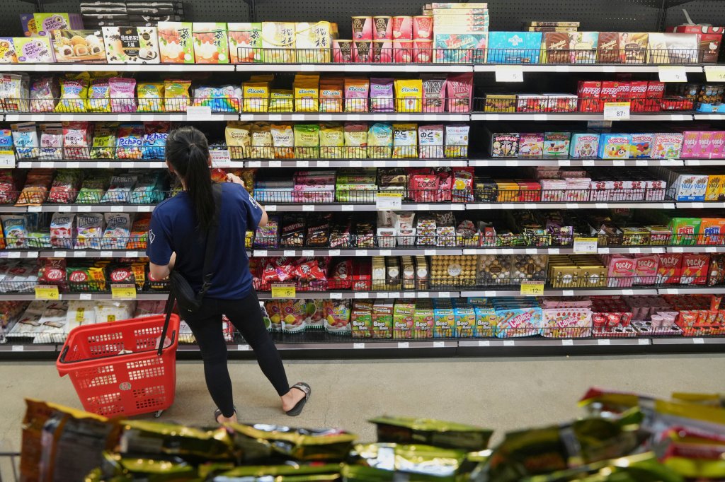 A person shops for candy and snacks at an Asian grocery store.