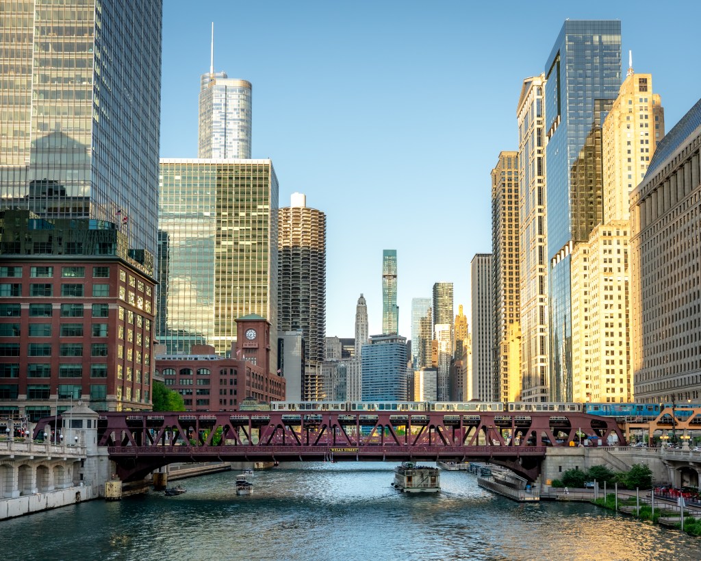 View of downtown Chicago, featuring the Chicago River and a train crossing a bridge.