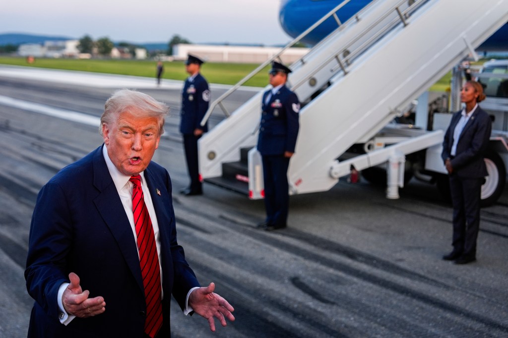 Donald Trump speaking to reporters at an airport.
