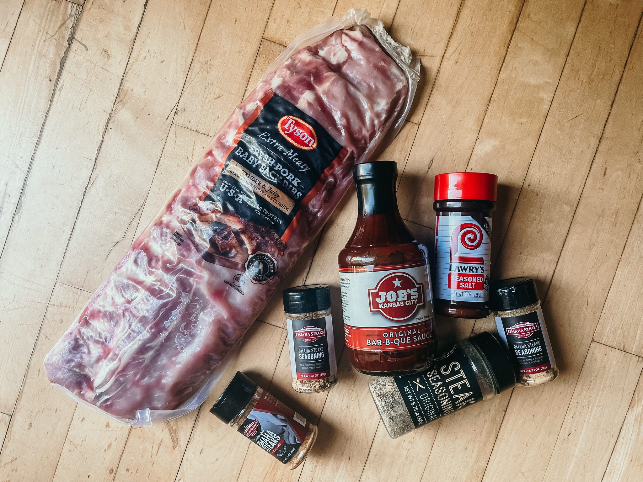 a rack of ribs with a few sauces and seasonings beside it