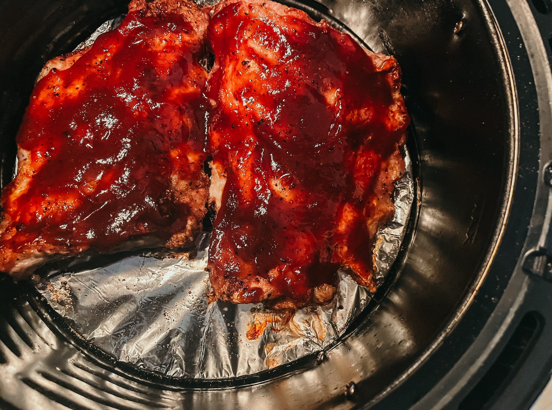 two half racks of barbecue ribs in an air fryer
