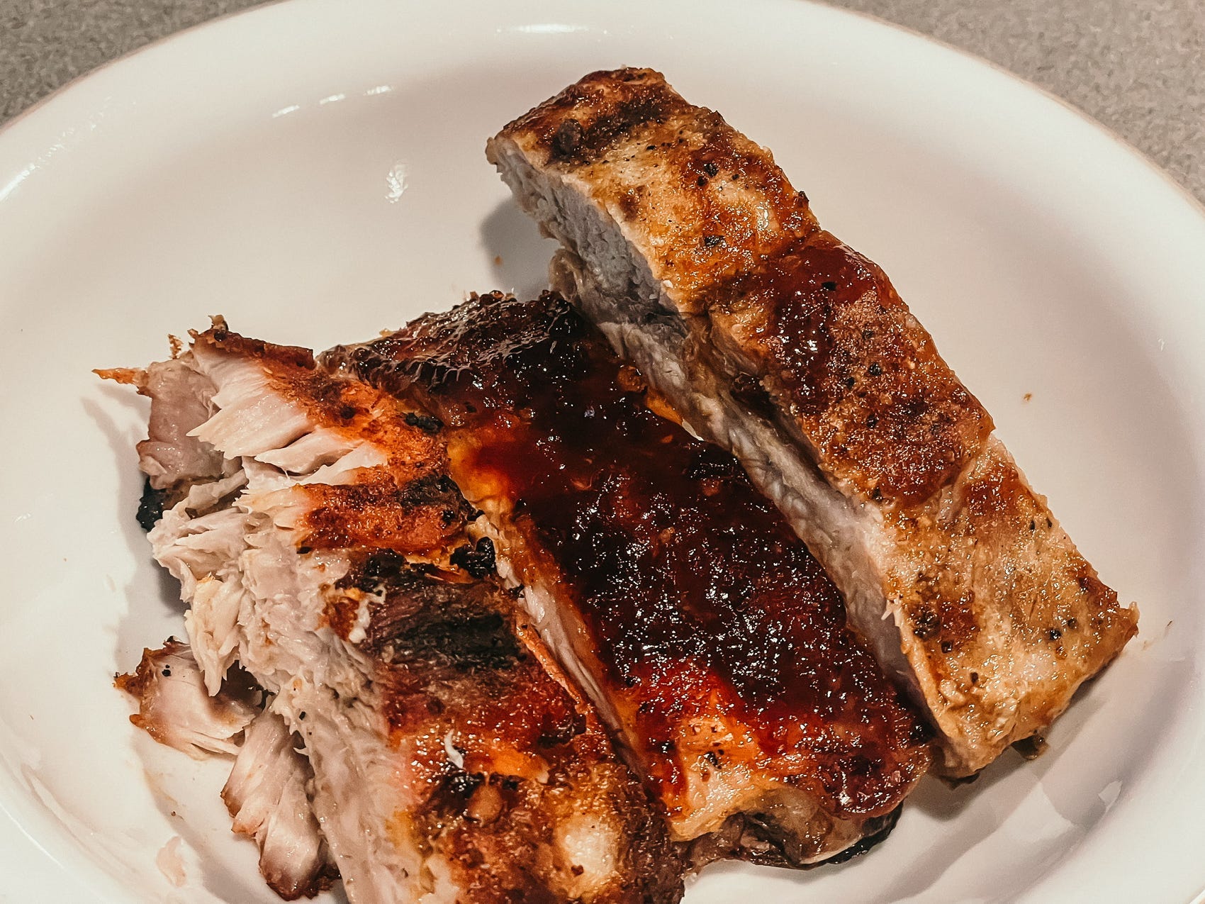 three separate ribs on a small white plate