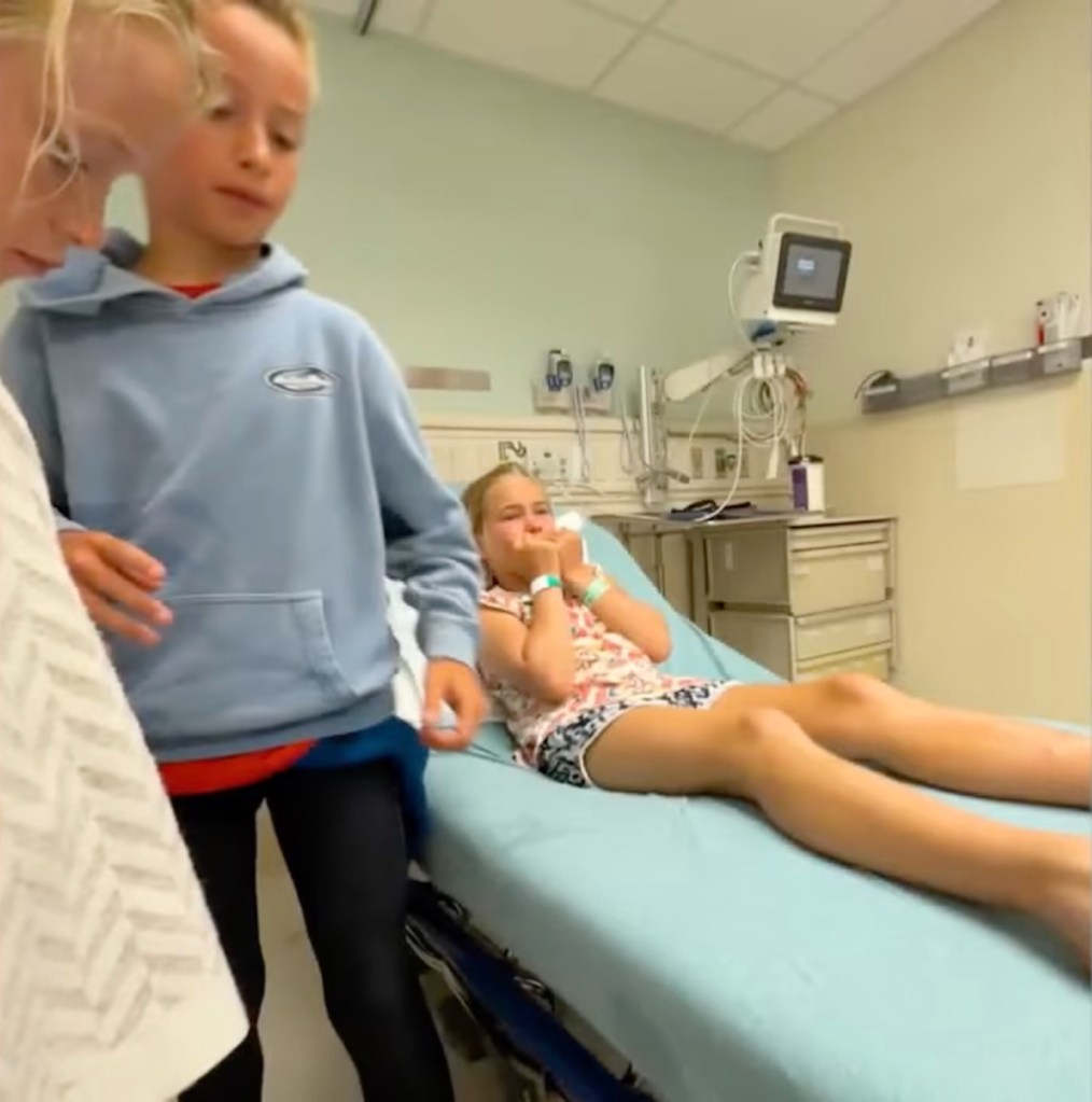 Nine-year-old girl in hospital bed with siblings.