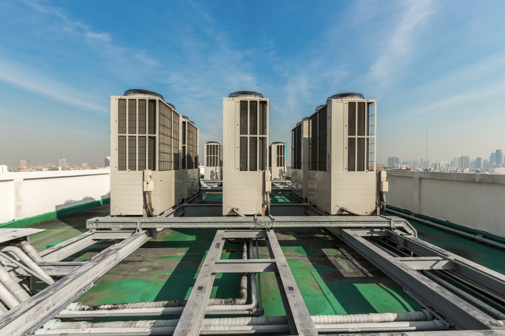 Industrial air conditioning units on a skyscraper rooftop.