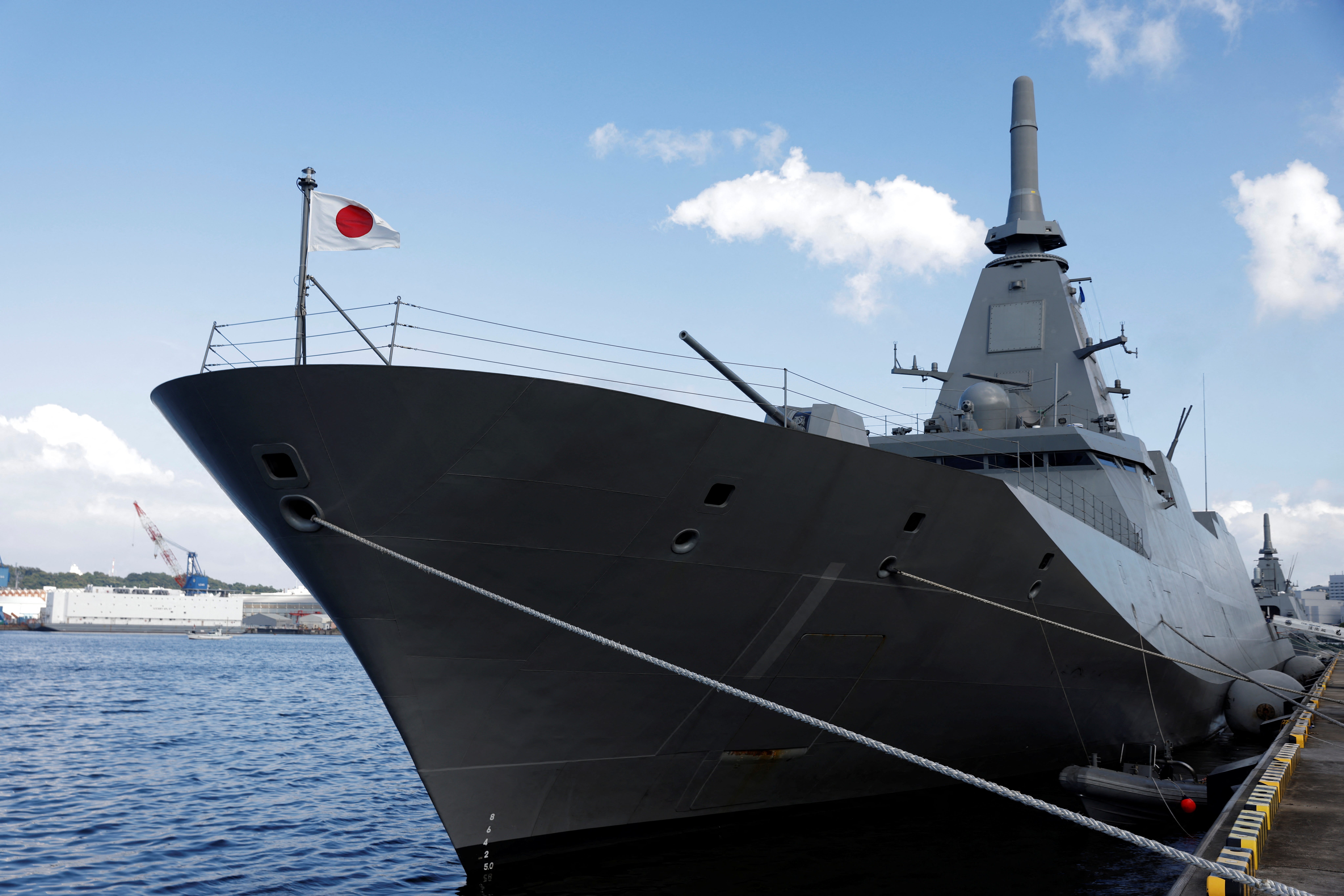The bow of a Mogami-class frigate can be seen as it's docked.