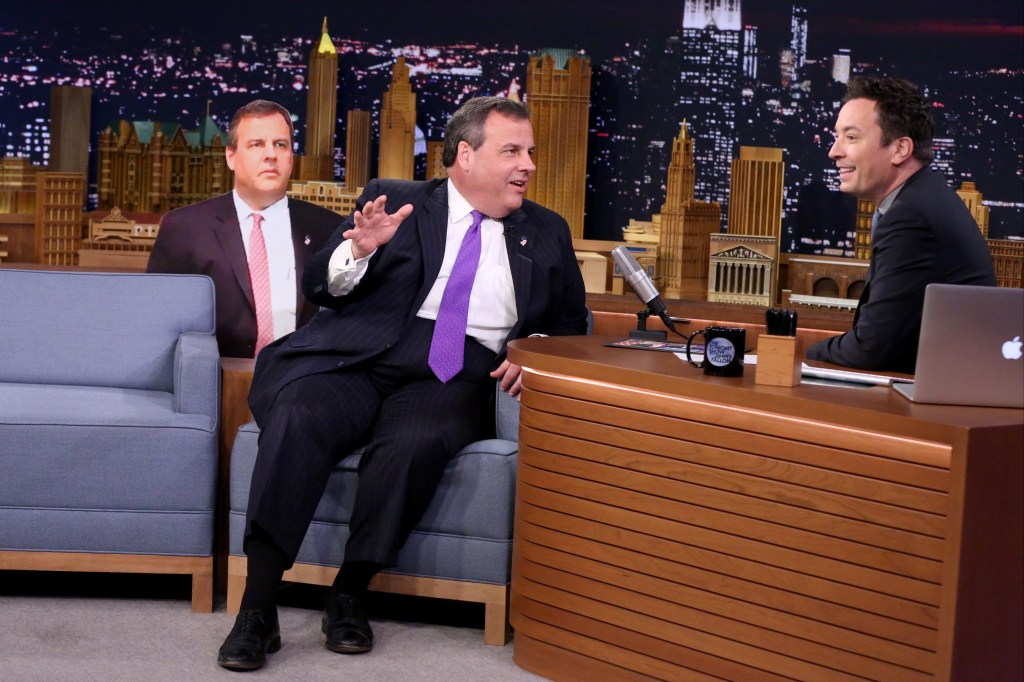 Jimmy Fallon in a dark suit, Chris Christie in a black suit, white shirt and purple tie.