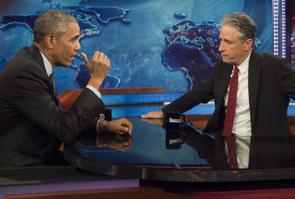Barack Obama and Jon Stewart wearing dark suits and ties.