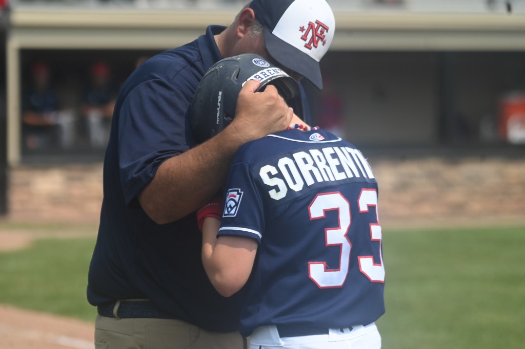 Farifield's Joe Sorrentino (33) gets comforted by first base coach David Gryga after making the first out of the 6th inning down five runs.