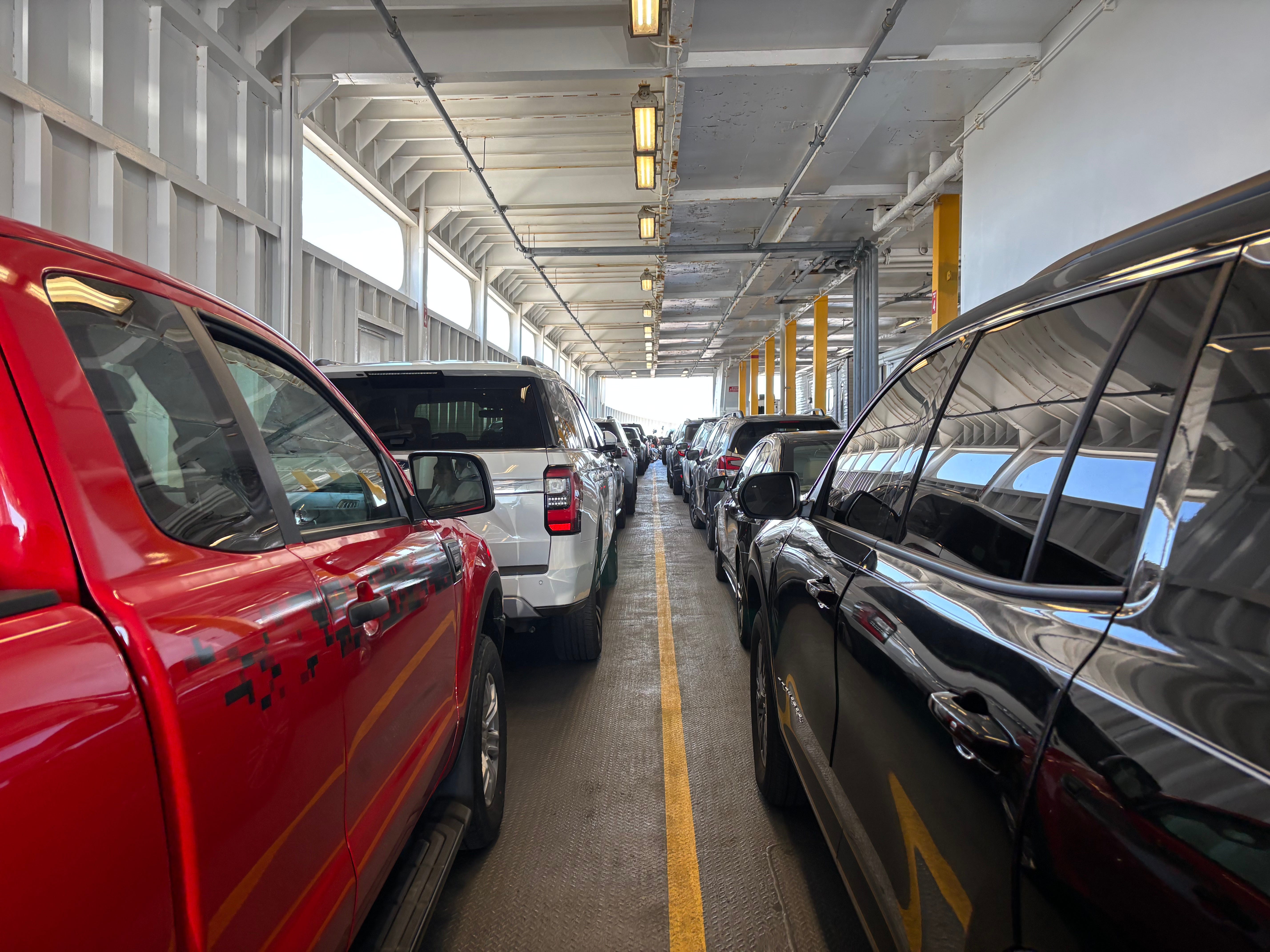 Two rows of cars pulled onto a ferry.