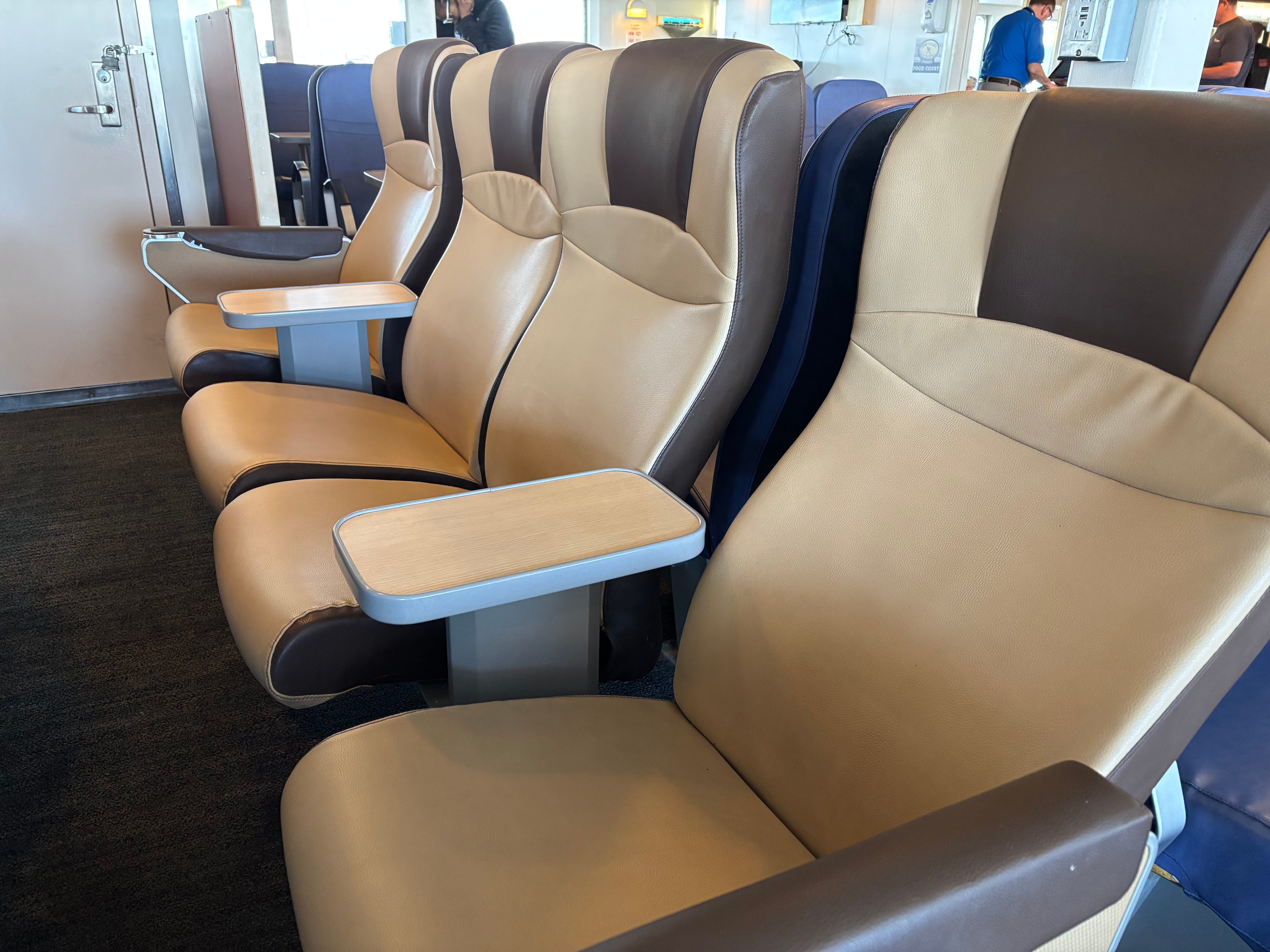 An empty row of cushioned seats inside a ferry.