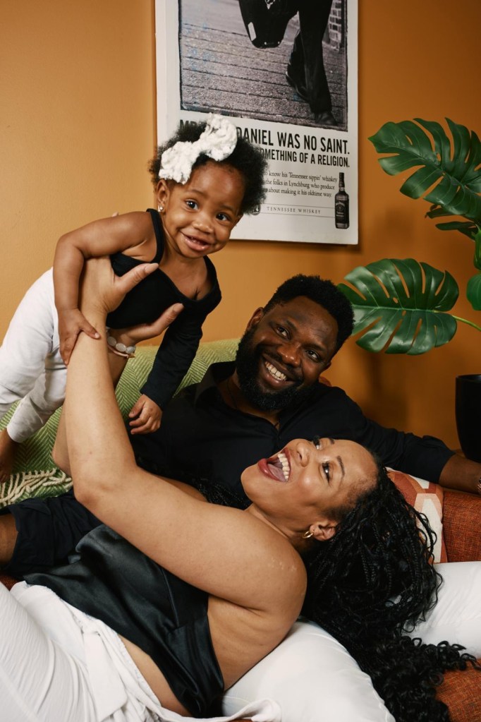 Family photo of parents playing with their baby daughter.