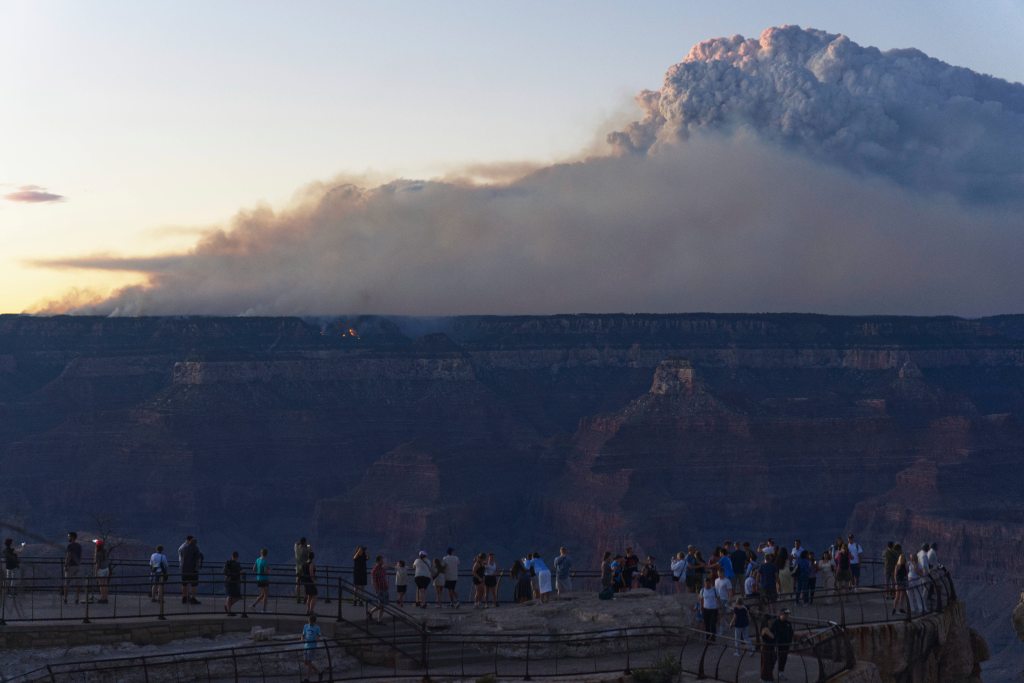 Smoke and a pyrocumulus cloud rises at sunset from the Dragon Bravo fire at the Grand Canyon as seen from Mather Point near Grand Canyon Village