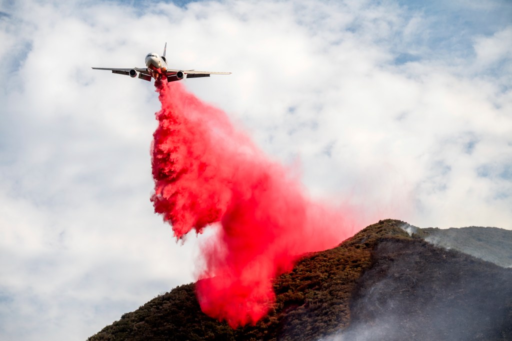 Air tanker dropping fire retardant on a wildfire.