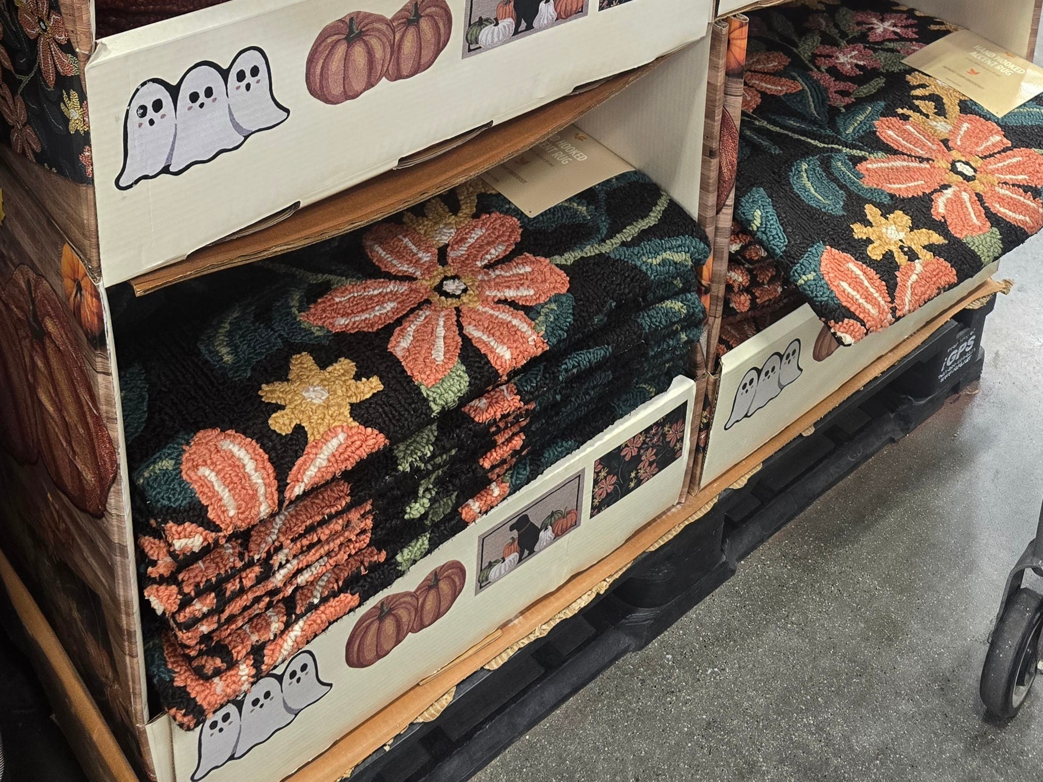 A variety of fall-themed accent rugs on display at Costco.