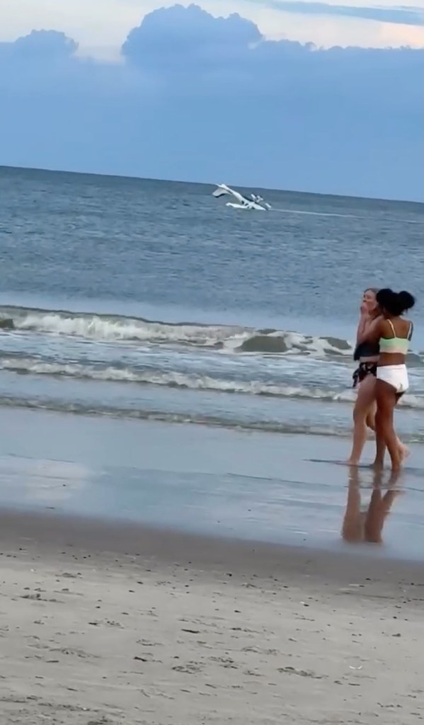 Small plane crash-landing in the ocean, as seen from the beach.