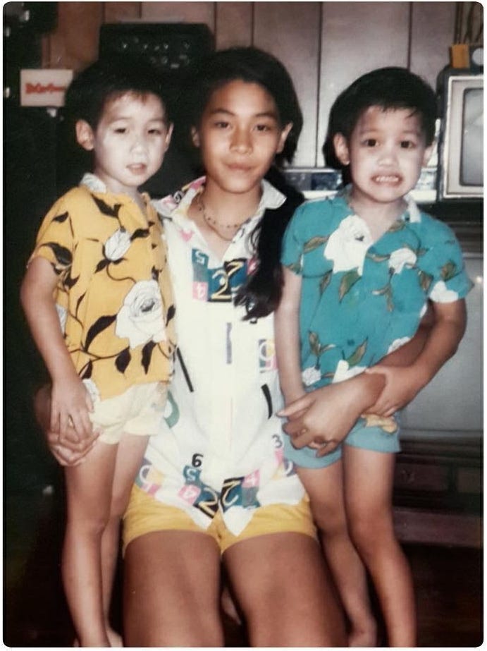 A young Metinee carrying two of her younger brothers.