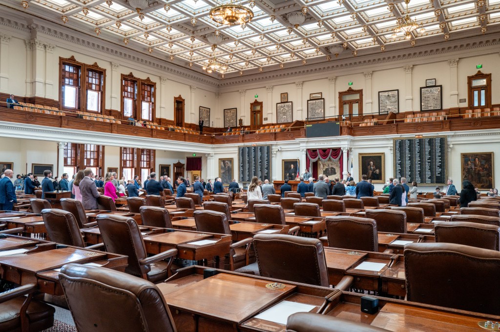 Texas House of Representatives chamber with lawmakers present.