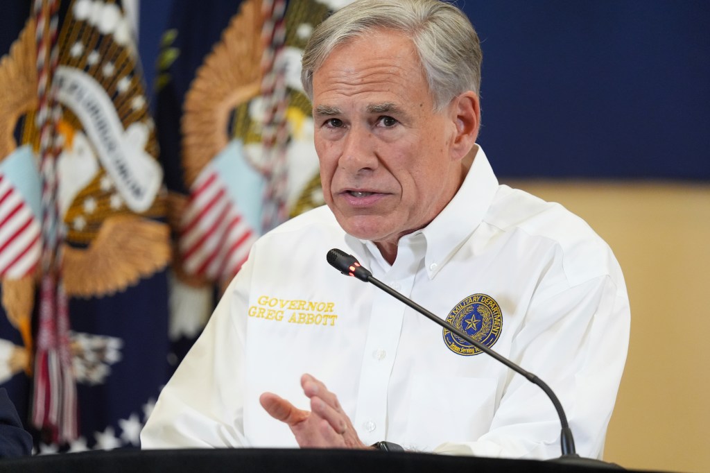 Governor Greg Abbott speaking at a podium.