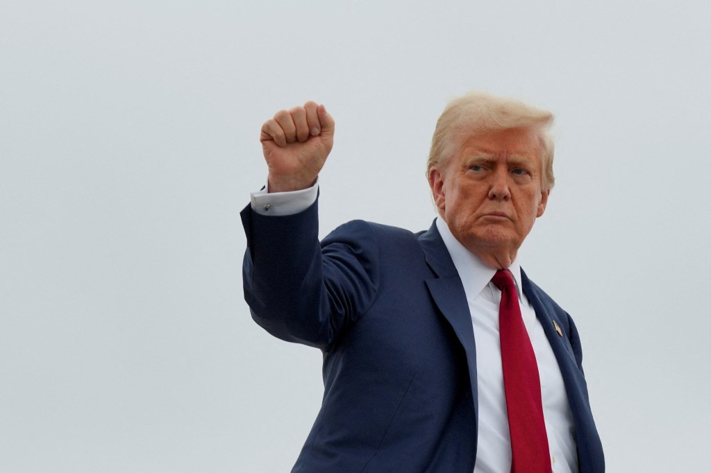 President Trump raises his fist while boarding Air Force One.