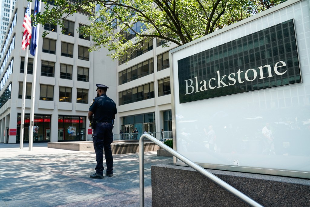 Police officer standing outside the Blackstone building in New York City.