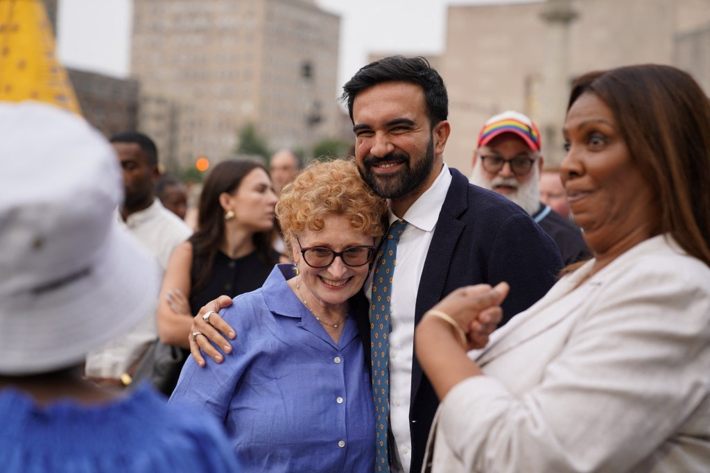 Zohran Mamdani embracing a supporter at a National Night Out event.