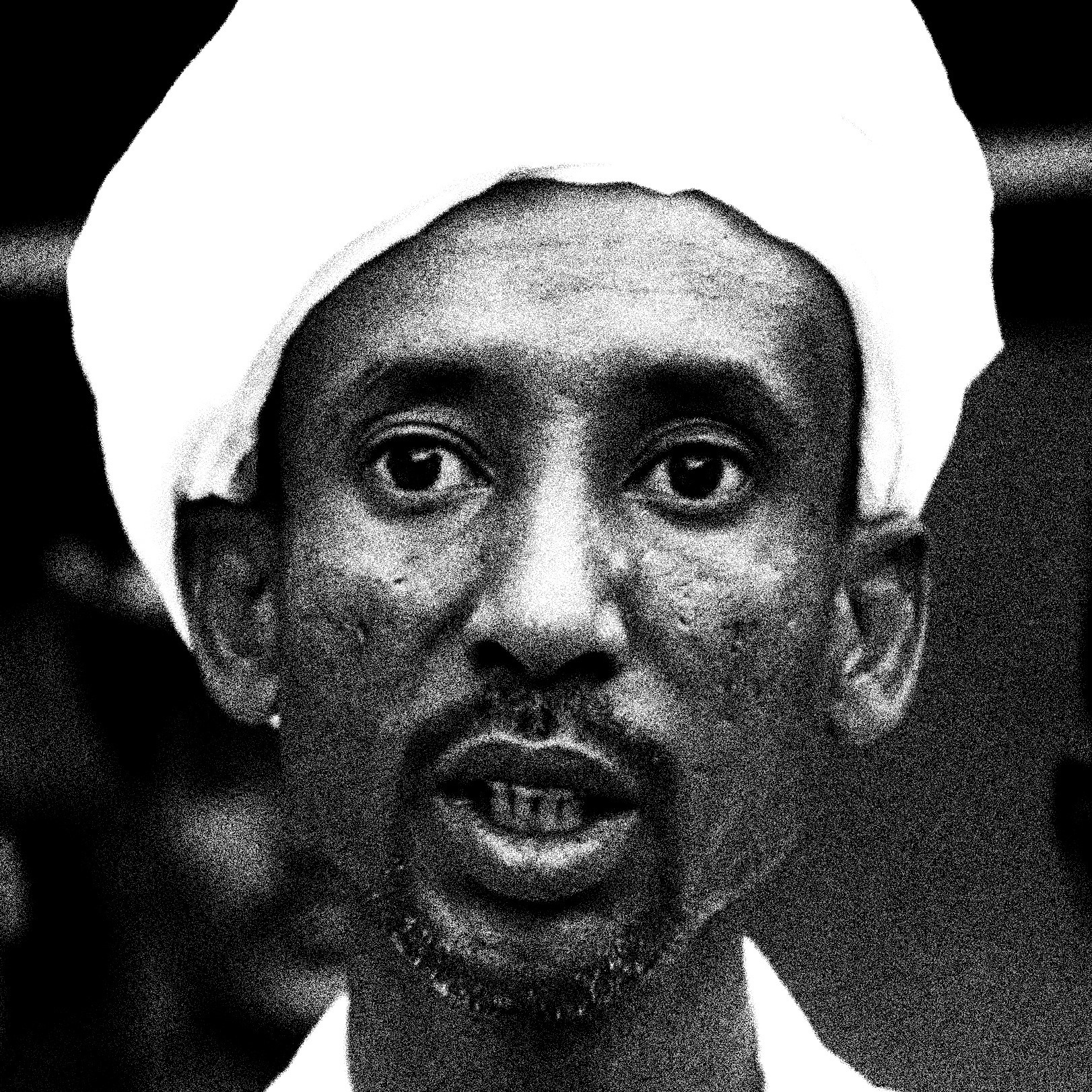 black-and-white photo of man with goatee wearing white turban