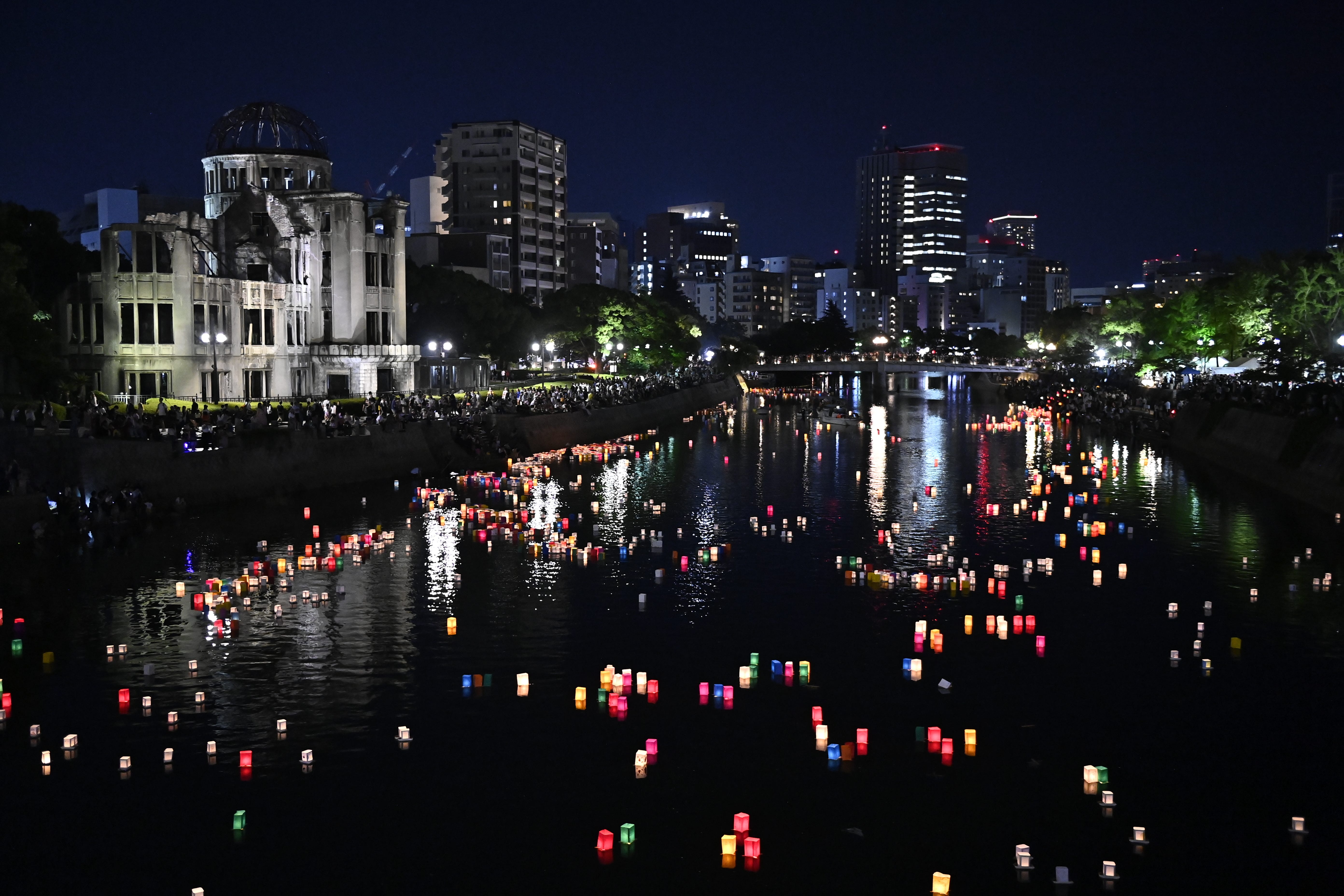 Candles and paper lanterns float on the Motoyasu River in front of the Atomic Bomb Dome.