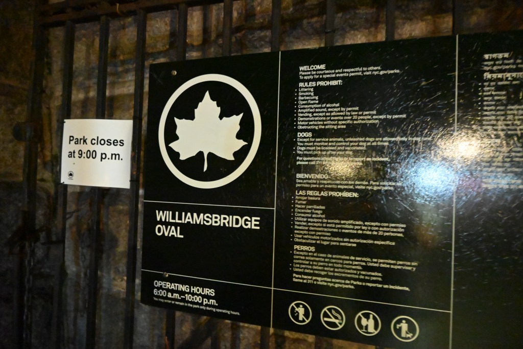 Williamsbridge Oval park sign with rules and operating hours.