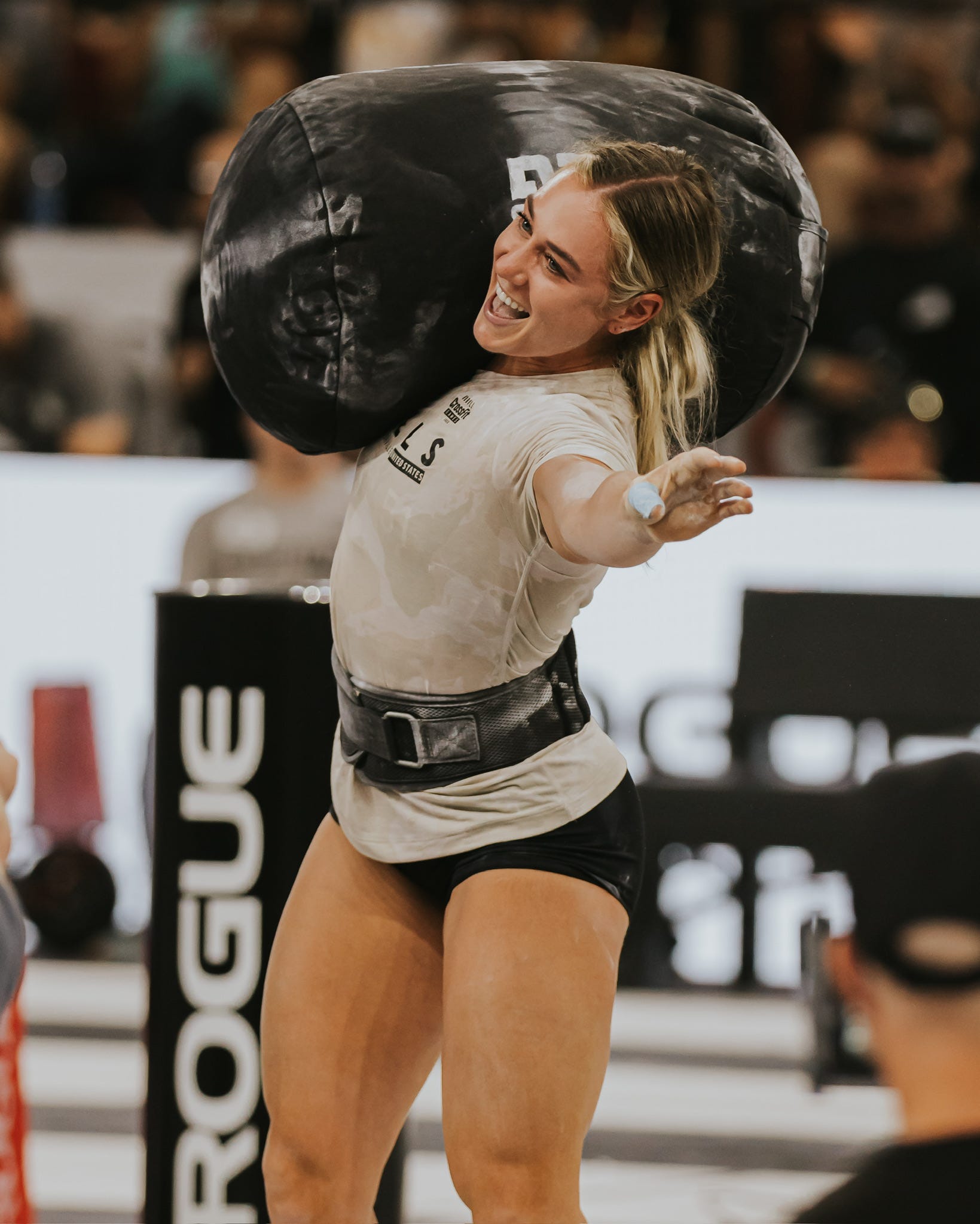 An image of athlete Brooke Wells lifting a heavy sandbag at the CrossFit Games