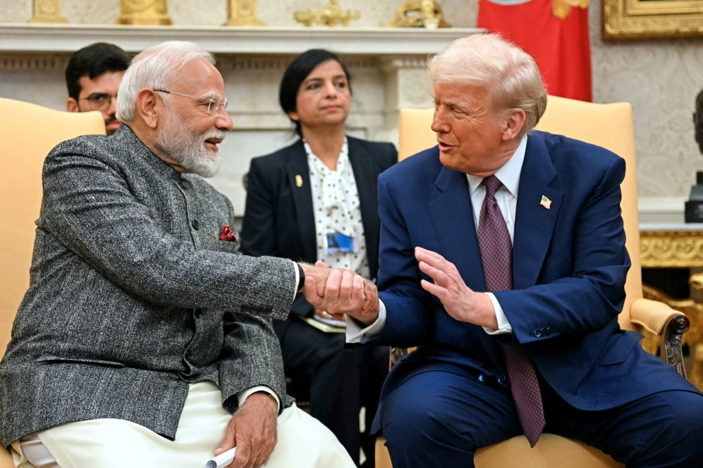 Narendra Modi and Donald Trump shaking hands.