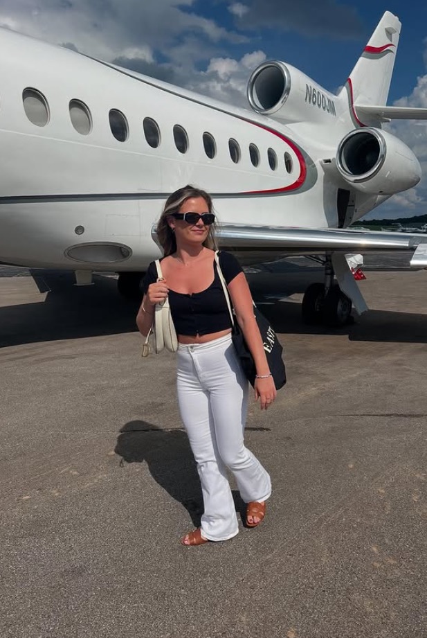 Woman standing in front of a private jet.