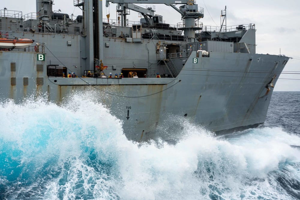 Waves crash against the side of the Lewis and Clark-class dry cargo ship USNS Alan Shepard