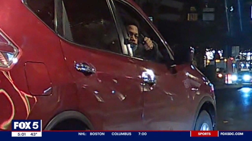 A man pointing a gun out of a car window during an attempted carjacking that spanned from DC to Maryland in 2023.