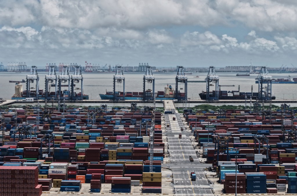 Trucks loaded with container move through a container terminal port in Shanghai, China, Thursday, Aug. 7, 2025.