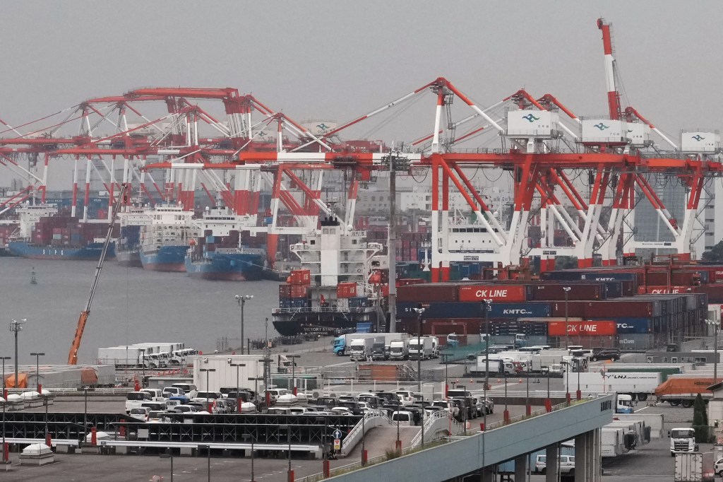 Shipping containers and a container ship are seen at the international cargo terminal in Tokyo on August 7, 2025.