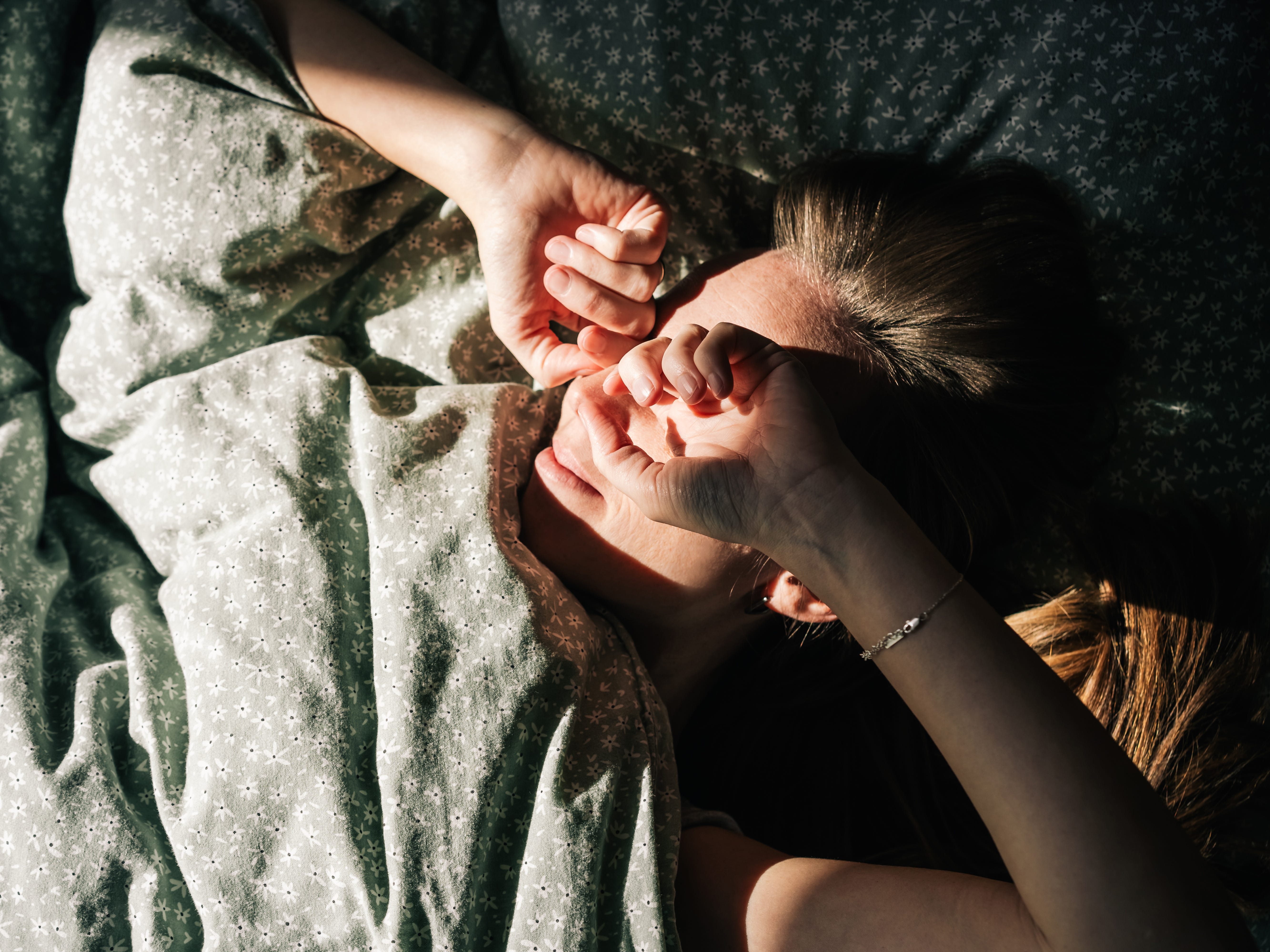 A woman waking up from a nap in the morning in the sunlight.