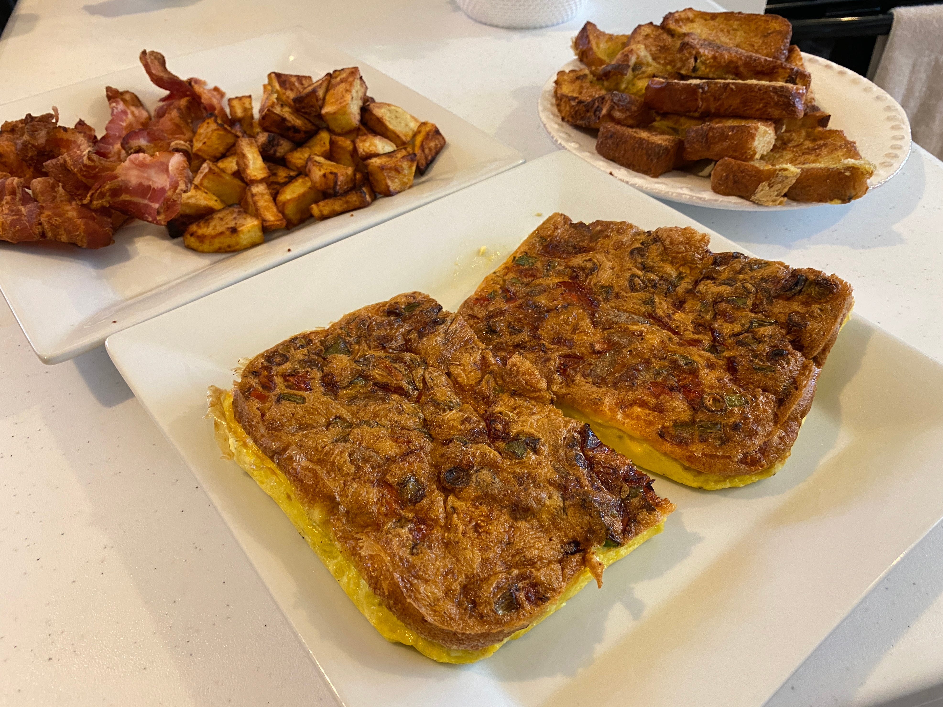 air fryer breakfasts laid out on white plates on white counter