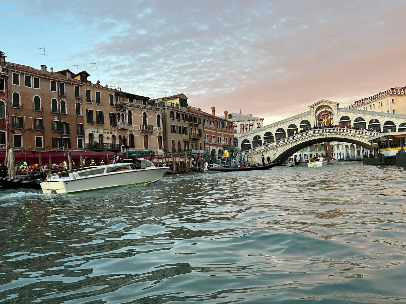 Venice canal with ship in distance at sunrise
