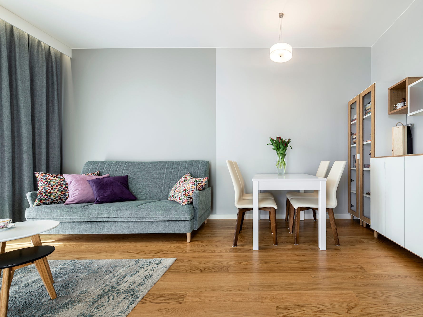 A living room and dining room with a couch, table, coffee table, and dresser.