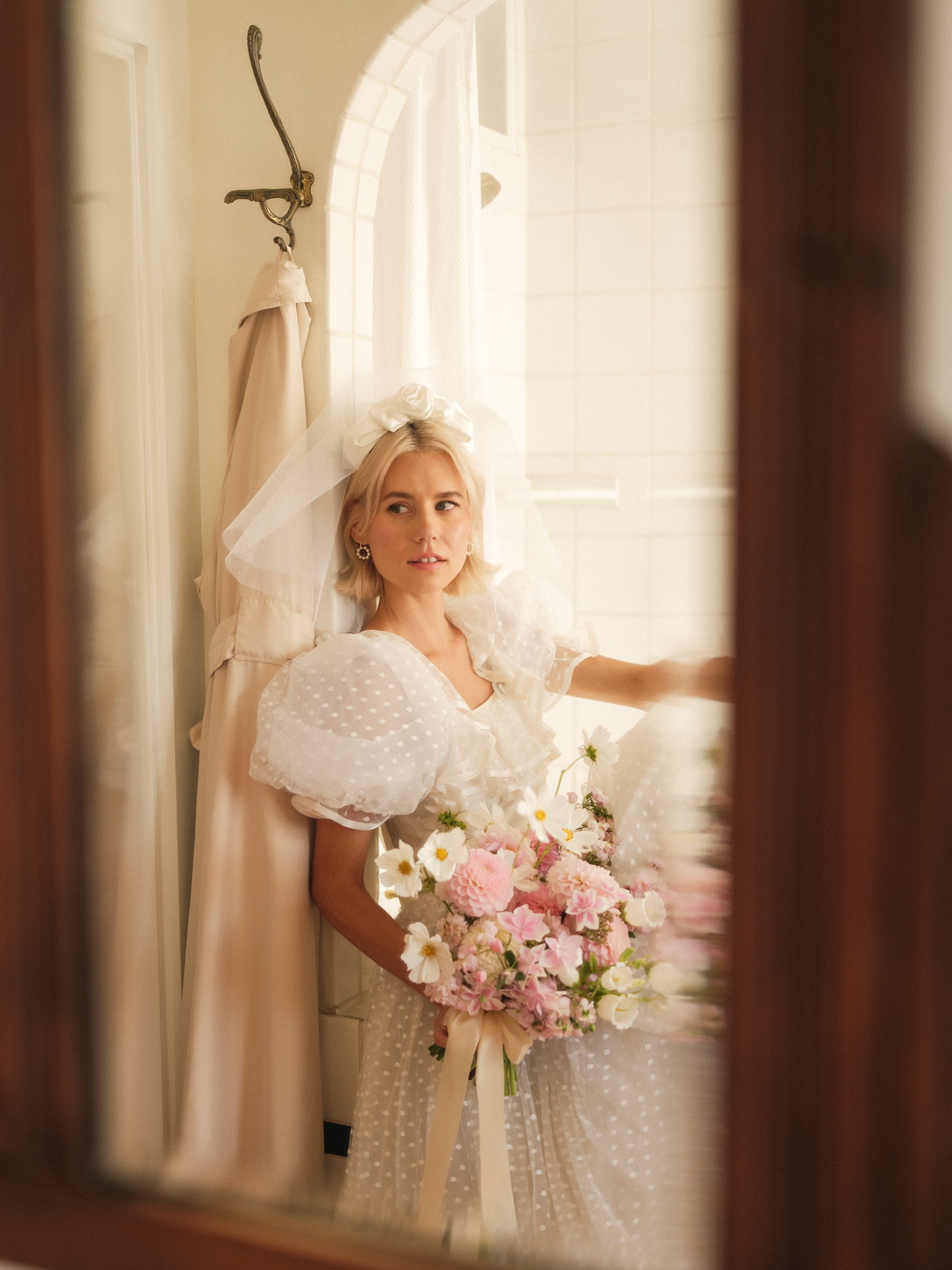 A bride looks at herself in a mirror.