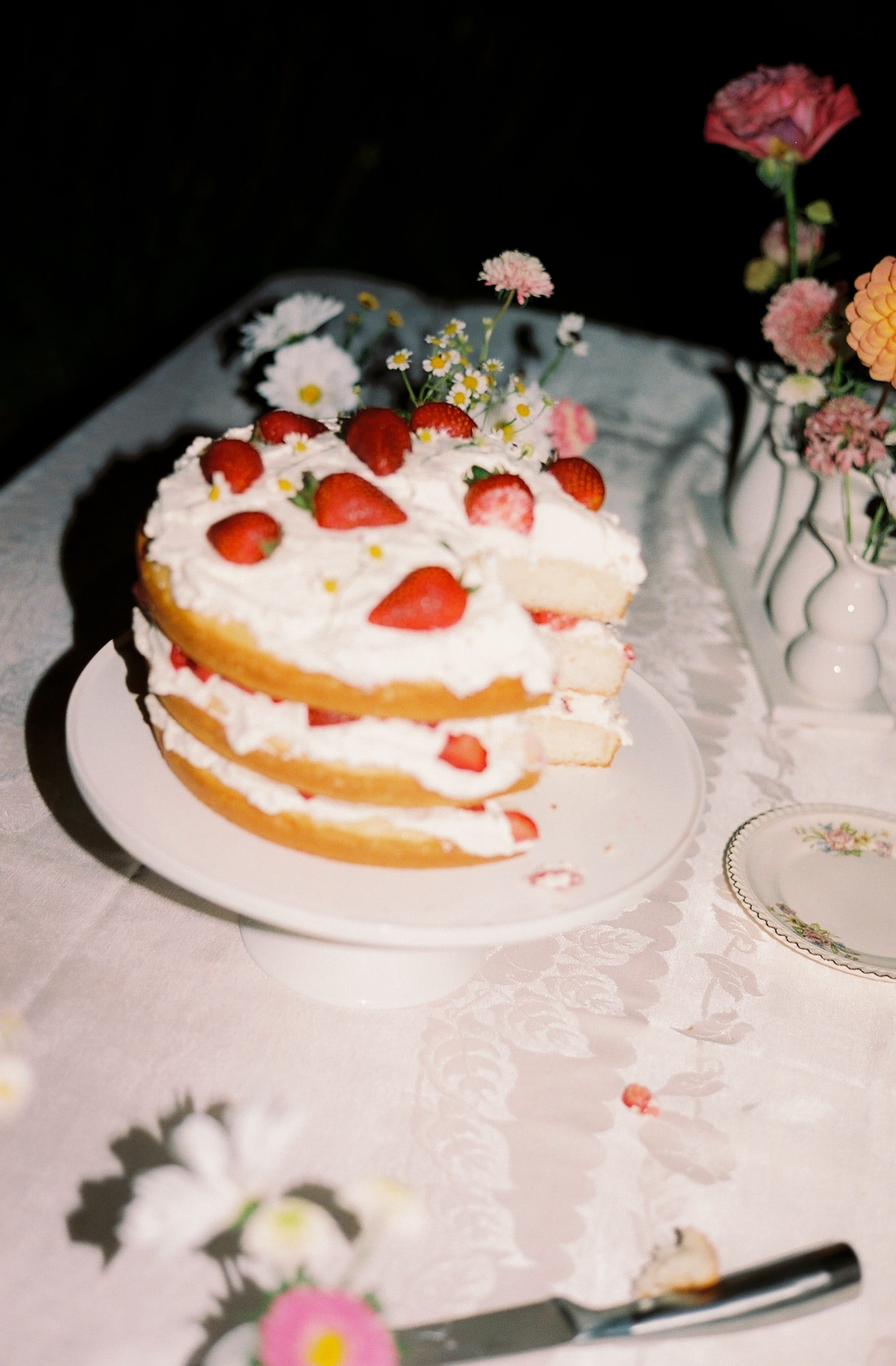 A small, three-tiered cake with strawberries on it.