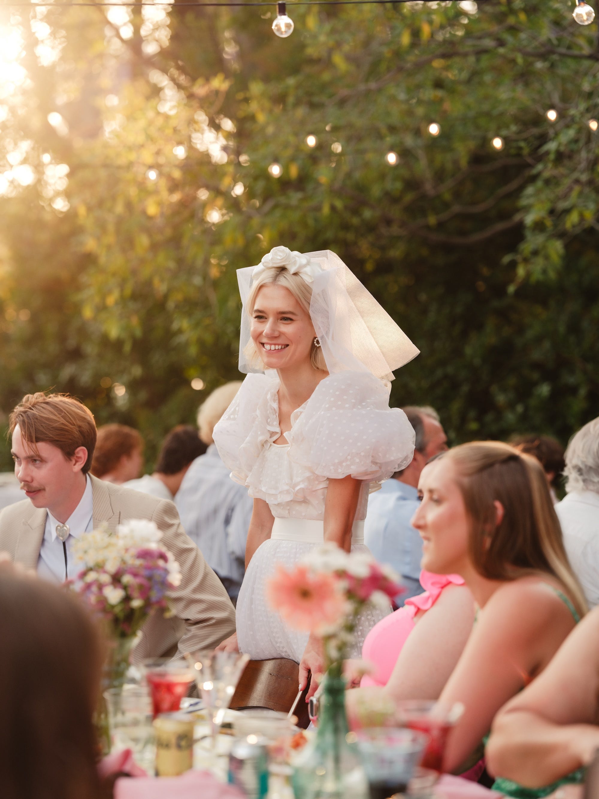 A bride stands in the center of her outdoor wedding ceremony.