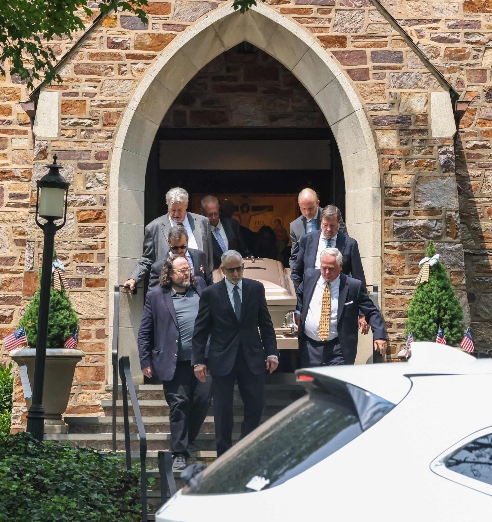 People carrying a casket at at church. 