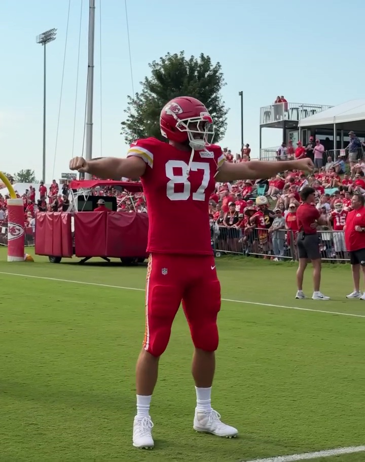 Travis Kelce on the field in a red football uniform. 