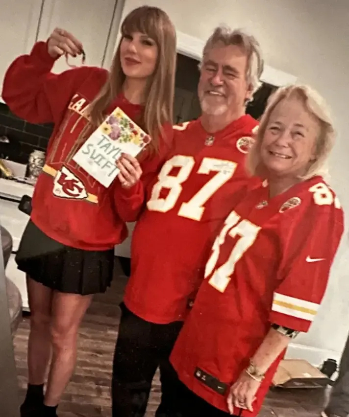 Ed Kelce, Maureen Maguire, and Taylor Swift in red jerseys. 