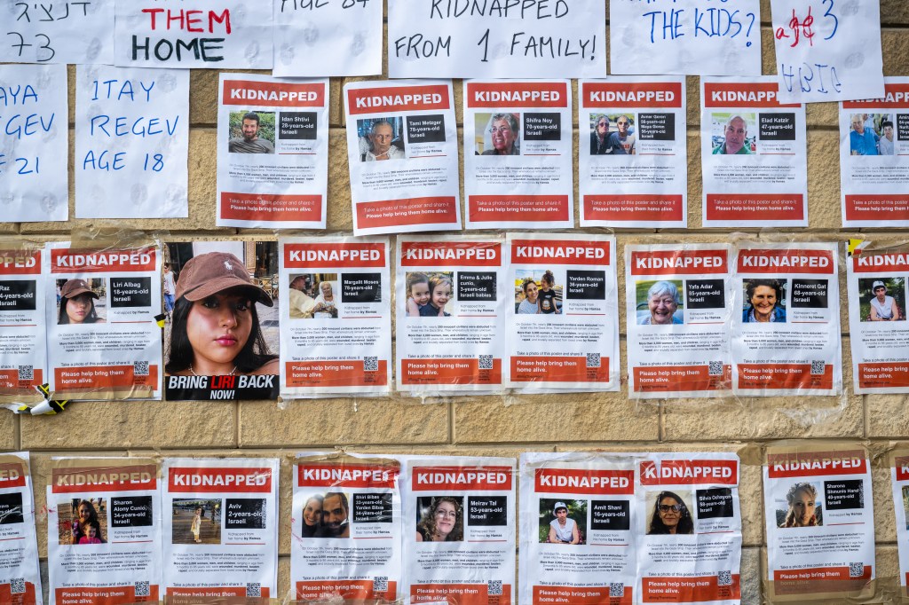 Photo of missing persons posters on a wall in Tel Aviv.