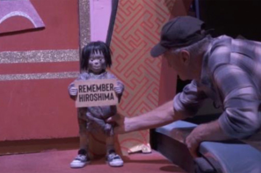 A doll holding a sign that says 